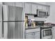This kitchen features stainless steel appliances and gray cabinets, and granite countertops at 45 Sycamore Ave # 116, Charleston, SC 29407
