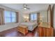 Cozy bedroom with hardwood floors, ceiling fan, two windows, and comfortable bedding at 5337 Hartford Cir, North Charleston, SC 29405