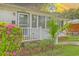 A close up of the front porch of a brick home, featuring azaleas, a palm tree, and white railing at 5337 Hartford Cir, North Charleston, SC 29405