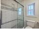 Contemporary shower featuring subway tiles with decorative band and a frameless glass door at 5337 Hartford Cir, North Charleston, SC 29405