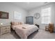 Cozy bedroom with comfortable bed, wood rocking chair, and ample natural light from the bright window at 603 Dunswell Dr, Summerville, SC 29486