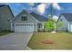 Well-maintained home with an attached garage, green lawn, and a young tree in the front yard at 603 Dunswell Dr, Summerville, SC 29486