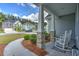 Inviting front porch with stone supports, white rocking chairs, and a view of the neighborhood at 603 Dunswell Dr, Summerville, SC 29486