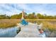 Dock with wooden chairs and an umbrella overlooking the marshland at 630 Cain Dr, Mount Pleasant, SC 29464