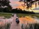 Waterfront scene with dock, boat, and serene sunset reflection on the water at 630 Cain Dr, Mount Pleasant, SC 29464