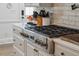 Close up on stainless steel range top, white cabinets, and white subway tile backsplash in kitchen at 630 Cain Dr, Mount Pleasant, SC 29464