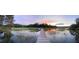 Panoramic view of marshland with a long dock leading to a boat, all reflecting a colorful sunset sky at 630 Cain Dr, Mount Pleasant, SC 29464