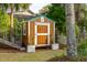 Backyard shed with a green roof and wood paneling surrounded by well-kept landscaping at 630 Cain Dr, Mount Pleasant, SC 29464