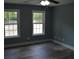 Bedroom features two windows, neutral walls, and wood-look flooring at 708 Old State Rd, Goose Creek, SC 29445