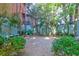 Serene backyard with gravel area, mature trees, and blue fence, ideal for enjoying nature in a peaceful setting at 78 Society St, Charleston, SC 29401