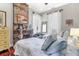 Inviting bedroom featuring twin beds, exposed brick fireplace, and bright, airy windows at 78 Society St, Charleston, SC 29401