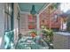 Charming front porch features a glass table, teal accents, and hanging floral baskets at 78 Society St, Charleston, SC 29401