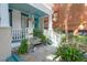 Inviting front porch with teal ceilings, painted brick accents and a charming seating area at 78 Society St, Charleston, SC 29401