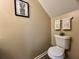 Bathroom toilet featuring neutral walls, decorative towels, and plant art at 7870 Nummie Ct, North Charleston, SC 29418