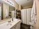 Well-lit bathroom featuring a white vanity, shower with curtain, and wooden shelving for storage at 7870 Nummie Ct, North Charleston, SC 29418