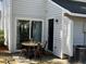 Outdoor patio with table, chairs, sliding glass door, and black entry door offers an inviting space at 7870 Nummie Ct, North Charleston, SC 29418