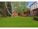 The home's backyard has a shed, a deck, and a lush green lawn surrounded by trees at 8147 Waltham Rd, North Charleston, SC 29406