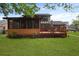 Expansive backyard featuring a deck, screened porch, lush lawn, and a backdrop of mature trees at 8147 Waltham Rd, North Charleston, SC 29406