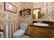 Charming powder room with floral wallpaper, wood vanity, and decorative mirror and fixtures at 8147 Waltham Rd, North Charleston, SC 29406