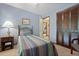 Well-lit bedroom with blue walls, carpet, closet, and a peek into the hallway at 8147 Waltham Rd, North Charleston, SC 29406