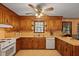 Well-lit kitchen with wooden cabinets, a large sink, and modern appliances under a ceiling fan at 8147 Waltham Rd, North Charleston, SC 29406