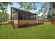 Backyard view of screened porch and deck with a lush green lawn surrounding the property at 8147 Waltham Rd, North Charleston, SC 29406