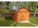 View of the storage shed on a well-manicured lawn surrounded by lush greenery and trees at 8147 Waltham Rd, North Charleston, SC 29406
