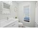 Well-lit bathroom with white vanity, oyster mirror, toilet and shower at 816 Club Cottage Rd, Edisto Beach, SC 29438