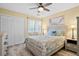 Bedroom with ceiling fan, light wood floors, and natural light from the bright windows at 816 Club Cottage Rd, Edisto Beach, SC 29438