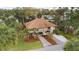 Charming elevated home featuring a cozy balcony and driveway amidst a lush, tropical landscape at 816 Club Cottage Rd, Edisto Beach, SC 29438