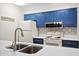 Updated kitchen with stainless steel sink, white countertops, backsplash, and blue cabinetry at 816 Club Cottage Rd, Edisto Beach, SC 29438