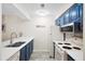 Cozy kitchen with blue cabinets, white countertops, a stainless steel sink, and updated appliances at 816 Club Cottage Rd, Edisto Beach, SC 29438