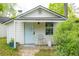 Charming backyard features a cozy porch with seating, a lovely blue door, and mature landscaping at 85 Colleton Dr, Charleston, SC 29407