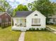 Charming white brick home featuring a covered porch with seating and a well-manicured front yard at 85 Colleton Dr, Charleston, SC 29407