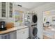 Well-lit laundry room with stacked washer/dryer, butcher block countertops, and stylish decor at 85 Colleton Dr, Charleston, SC 29407
