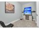 Carpeted bonus room has a mounted TV, a butterfly and flower decoration, as well as some storage shelves at 8618 Mcchune Ct, North Charleston, SC 29420