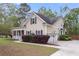 Charming home featuring a covered porch, attached garage, and well-kept landscaping at 8618 Mcchune Ct, North Charleston, SC 29420