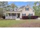 Charming home featuring a cozy front porch, dormer windows, and lush landscaping at 8618 Mcchune Ct, North Charleston, SC 29420