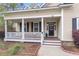 Inviting front porch with white columns, a wreath on the door, and a landscaped yard at 8618 Mcchune Ct, North Charleston, SC 29420