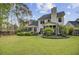 Spacious backyard featuring a well-manicured lawn, lush landscaping, patio, and screened porch at 9447 Harroway Rd, Summerville, SC 29485