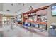 A fully stocked bar with wood trim, liquor, wine, and refrigerators sits below an analog clock at 9447 Harroway Rd, Summerville, SC 29485