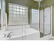 Bright bathroom featuring a glass-enclosed shower and a large soaking tub at 9447 Harroway Rd, Summerville, SC 29485