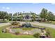 A grand clubhouse featuring a tiered rock waterfall and pond in front, showcasing Southern charm at 9447 Harroway Rd, Summerville, SC 29485