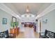 The clubhouse interior features a chandelier, bar, and seating under a tray ceiling, inviting gathering at 9447 Harroway Rd, Summerville, SC 29485