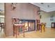 Inviting brick fireplace with roaring fire, lanterns, and seating in a bright and airy room at 9447 Harroway Rd, Summerville, SC 29485