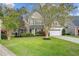 Beautiful two-story home with brick and siding exterior, complemented by lush landscaping at 9447 Harroway Rd, Summerville, SC 29485