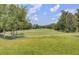 Beautiful golf course view with lush green grass, trees, and blue skies on a sunny day at 9447 Harroway Rd, Summerville, SC 29485