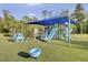 A colorful playground with slides and play equipment, set on a green turf surface with views of a pond at 9447 Harroway Rd, Summerville, SC 29485