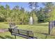 A serene pond with a fountain feature, surrounded by lush greenery and benches for relaxation at 9447 Harroway Rd, Summerville, SC 29485