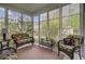 Charming sunroom with large windows, floral seating, and views of the landscaped yard at 9447 Harroway Rd, Summerville, SC 29485